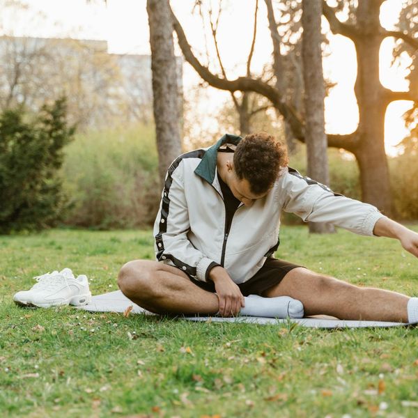 Man stretching outdoors at sunrise feeling refreshed and calm.